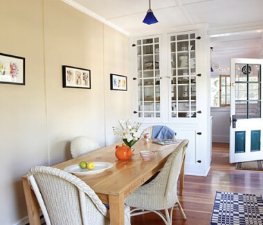 Living room dining table with wicker chairs.